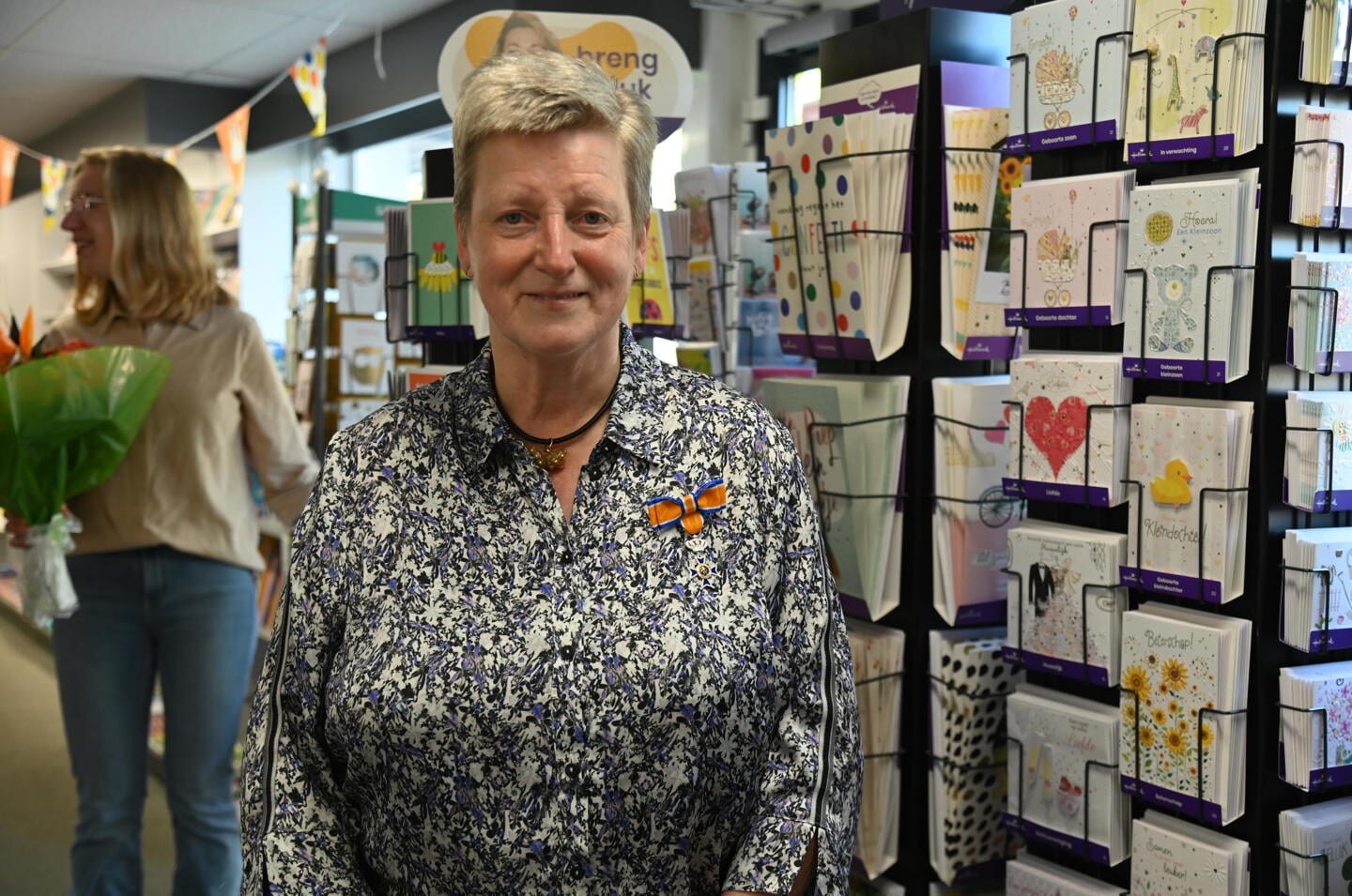Katie van Winkelen-Van Vossen kreeg het lintje opgespeld in haar boekhandel in Sint-Annaland.