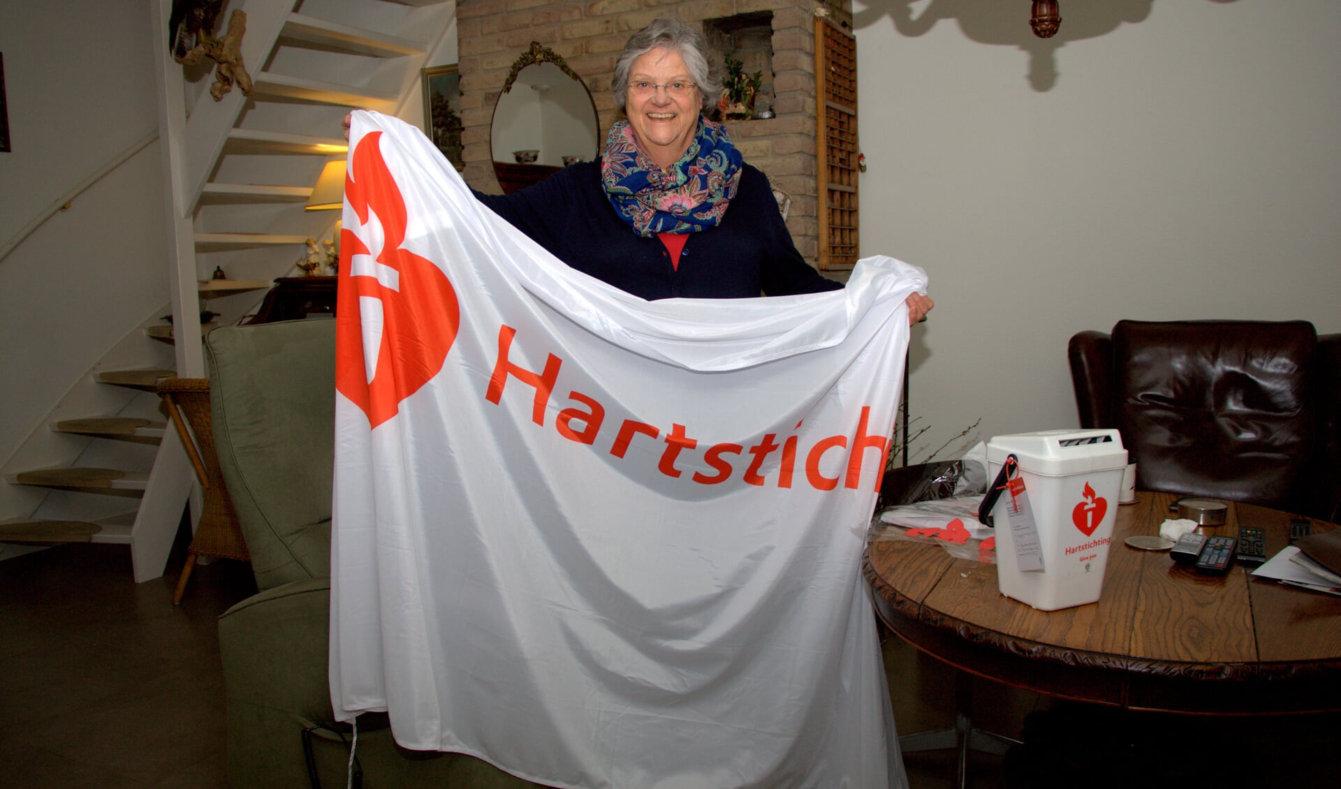Willemien Jongbloets toont trots de vlag van de Hartstichting.