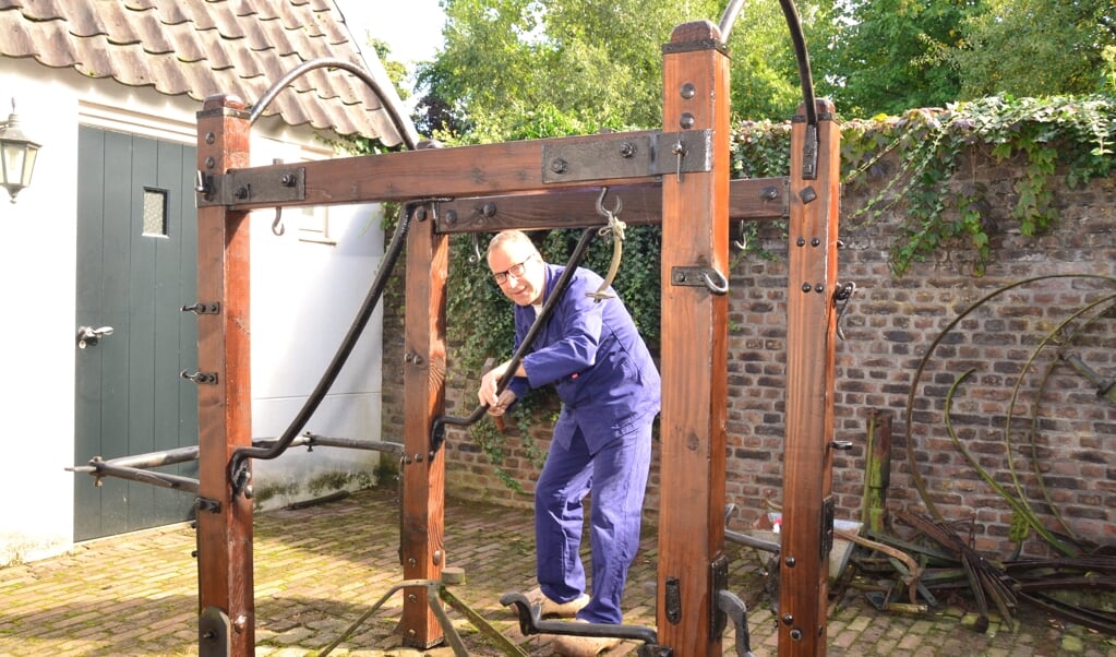 Bert van Son bij de door hem gerestaureerde hoefstal