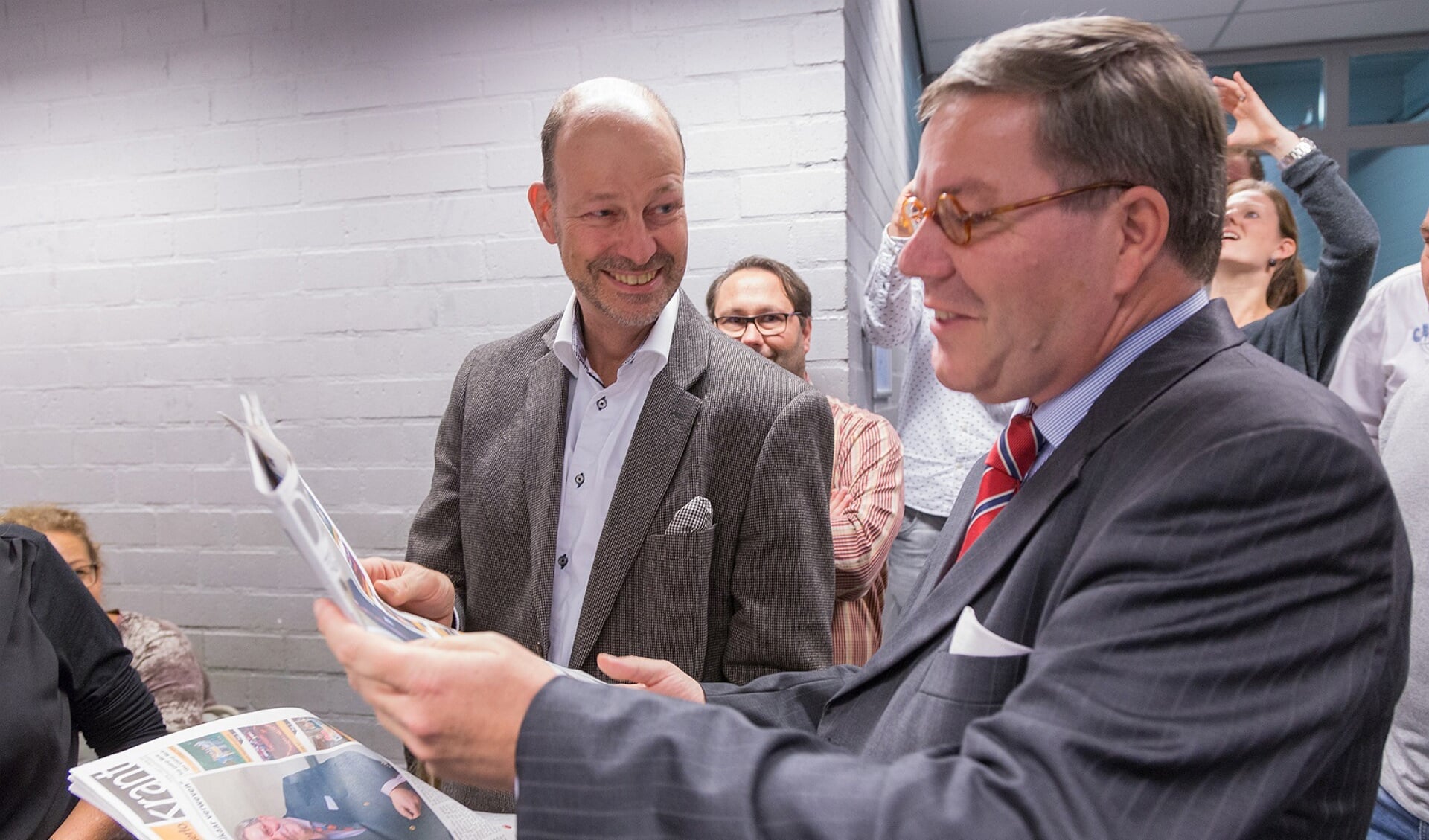 Guillaume van Stiphout en burgemeester Link (r) bladeren door de eerste editie.