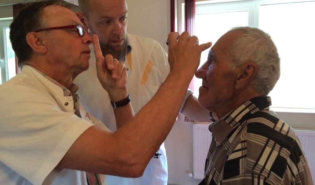 Leo Leenders en Roel Huiskens bekijken samen hoe een patiënt reageert.