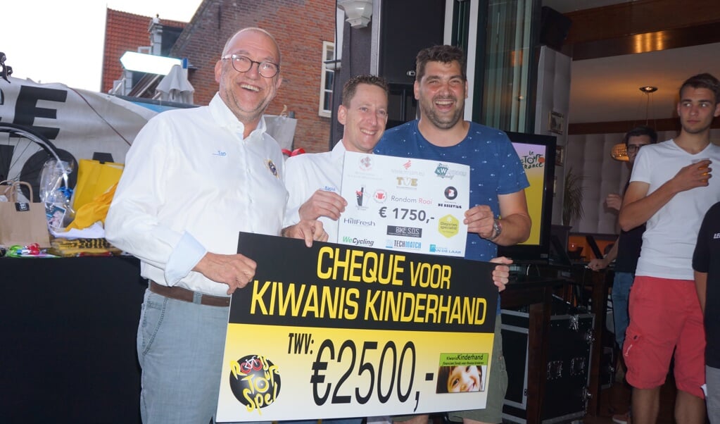 Ralf Dirven (r) reikt de cheque van Rondom Rooi uit nadat Kiwanis al een andere cheque ontving.