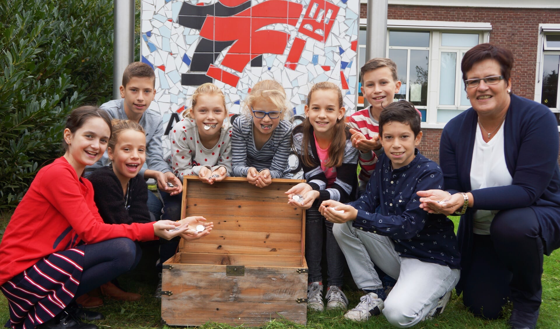 Kinderen van basisschool Eerschot waren de eerste de munten in ontvangst mochten nemen. Rechts: directrice Marjo Timmermans