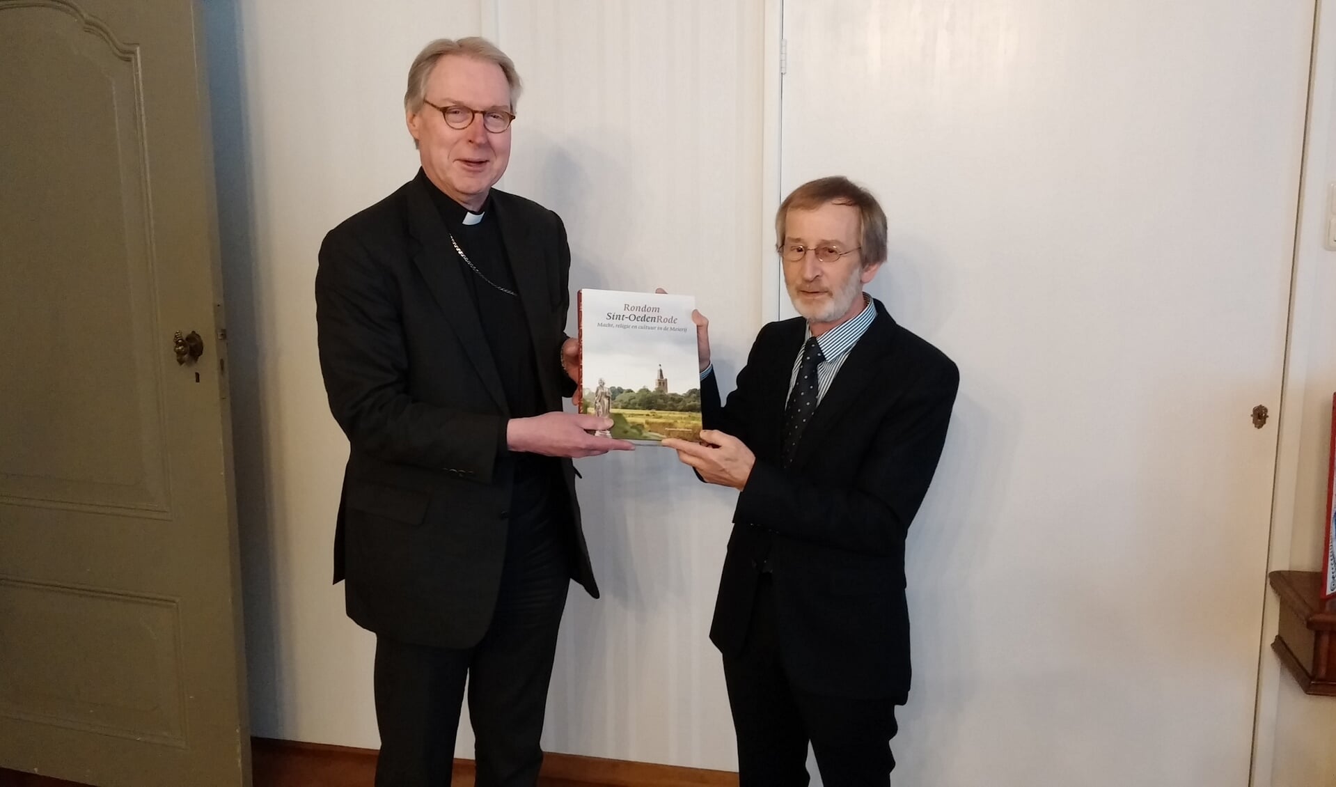 Bisschop De Korte neemt het boek in ontvangst.