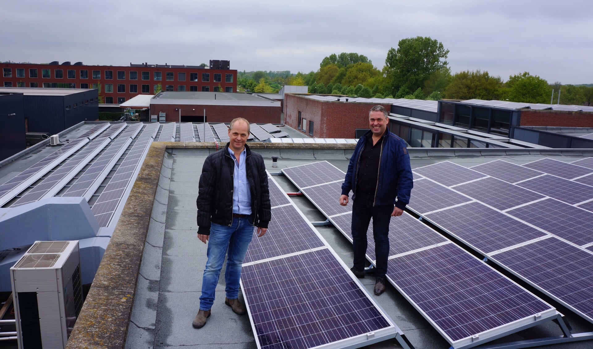 Hans (l) en Erik van Acht op het dak waar de eerste zonnepanelen zijn geplaatst. 