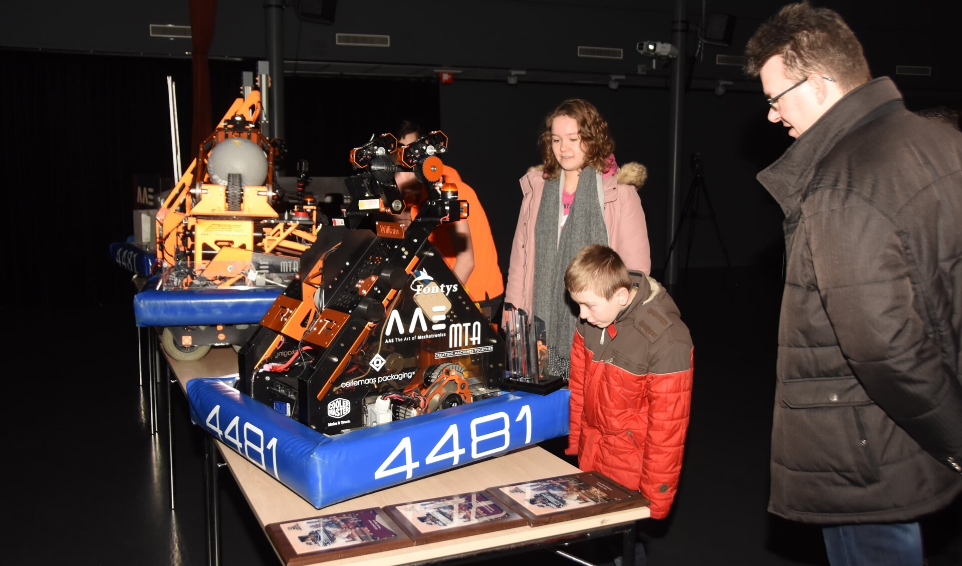 Familieleden vergapen zich aan de robots van eerdere jaren.