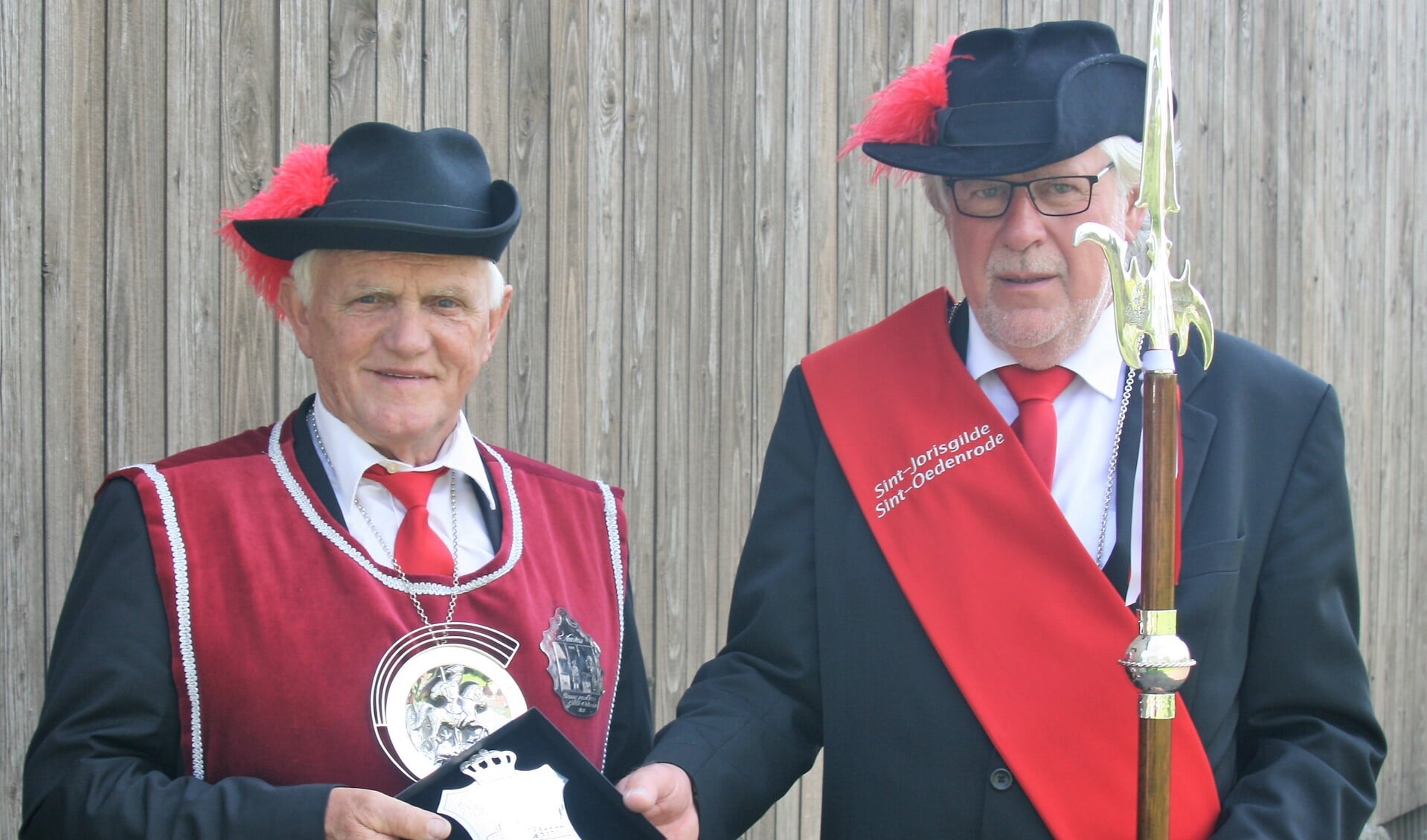 Gildekoning Piet van Heesch (l) schenkt zijn koningsschild aan hoofdman Henk Quinten.