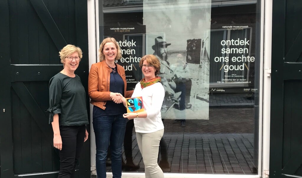 Op de foto reikt Rian van der Sman (bestuurlids werkgroep fairtrade Schijndel) het fairtradebordje uit aan Marike de Kroon (conservator) en Bernadette Keetels (coördinator VVV Schijndel). 