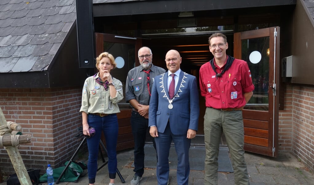 Burgemeester Van Rooij met de drie afgevaardigden van de scoutings. 