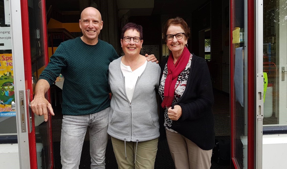 Carlo, Ine en Christine voor de hoofdingang van de school.