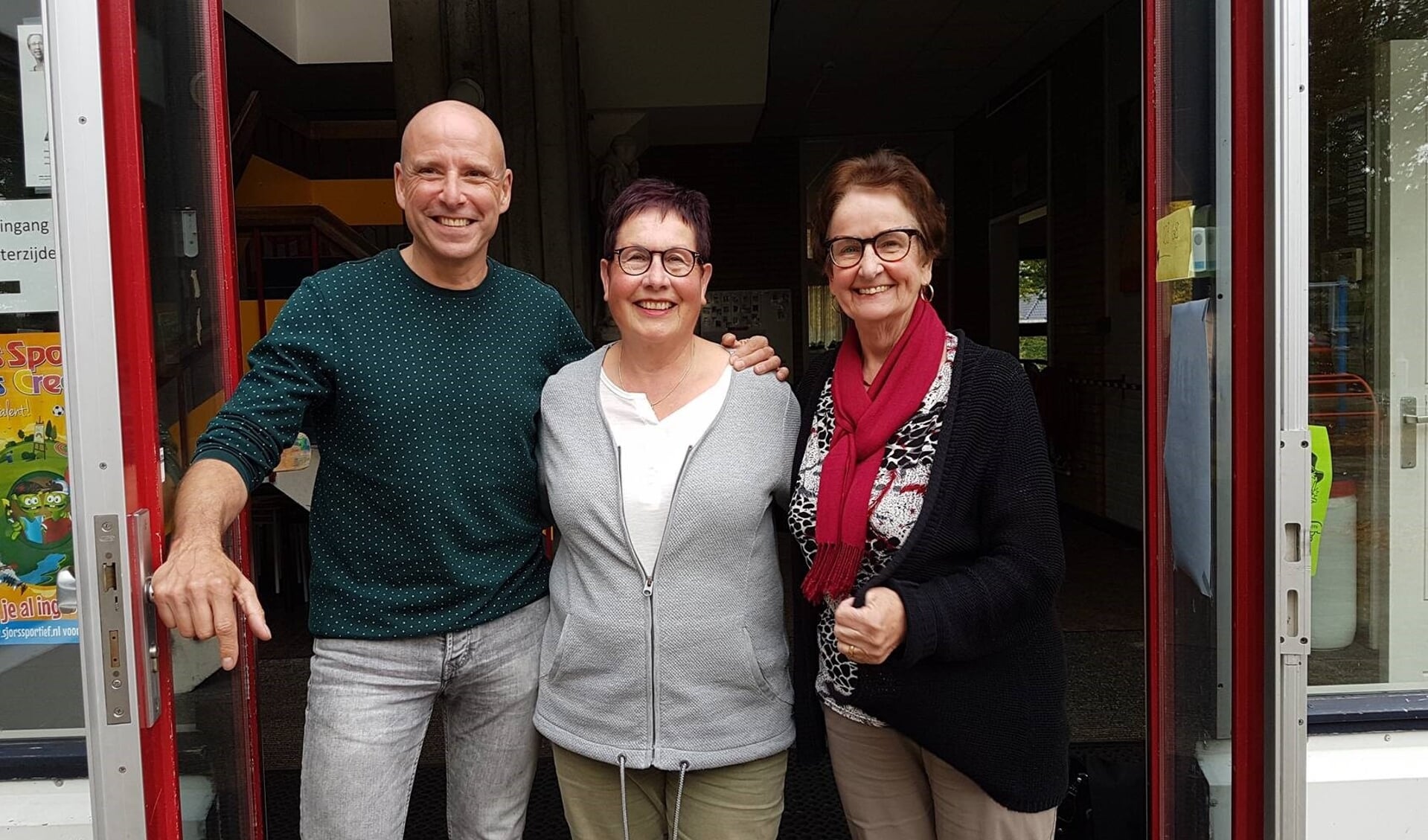 Carlo, Ine en Christine voor de hoofdingang van de school.