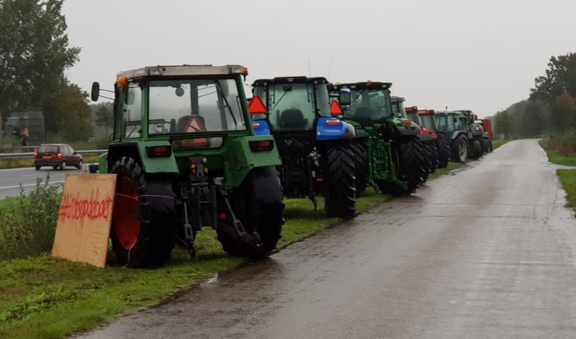 Aan de A50 staan deze landbouwvoertuigen geparkeerd.
