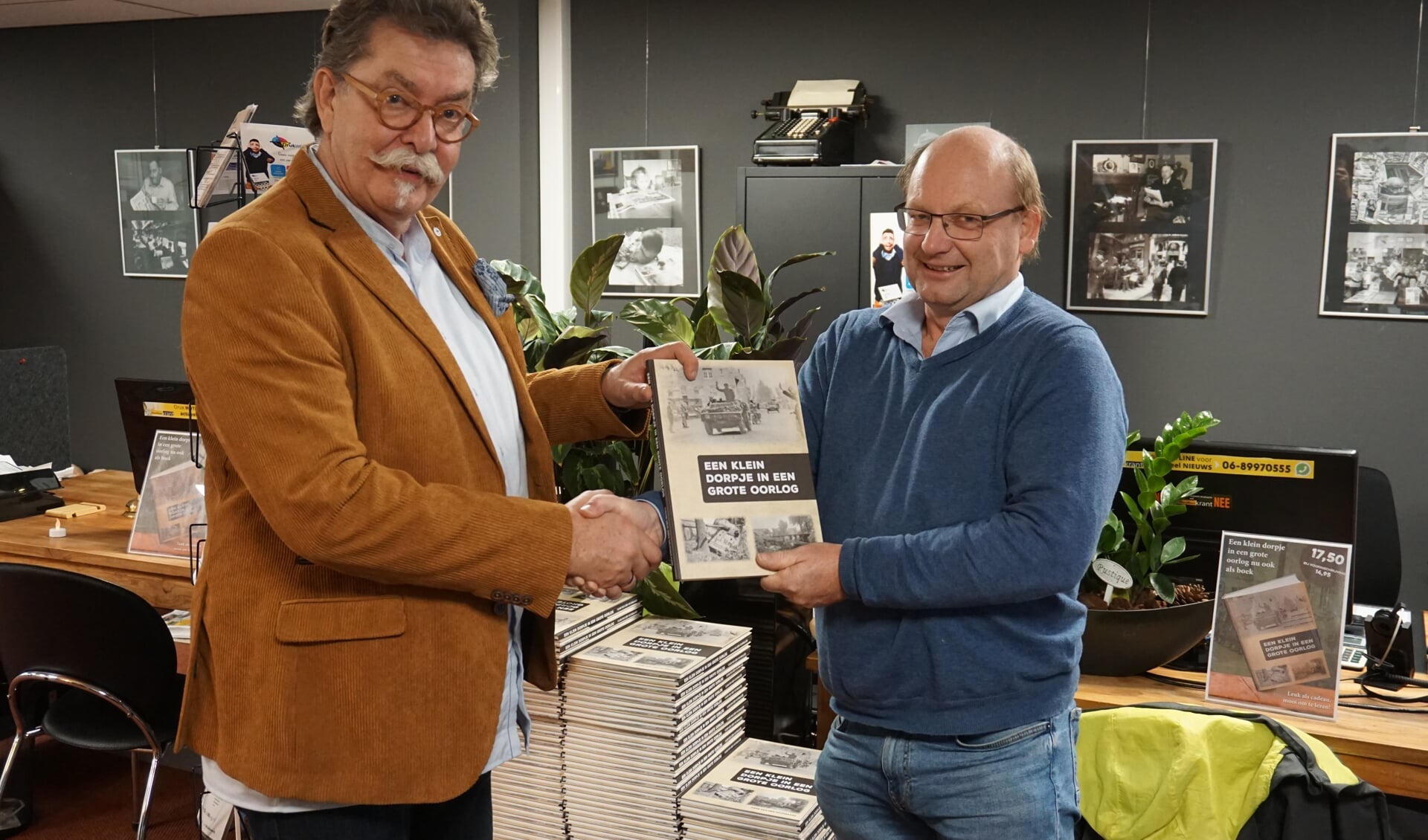 Hans van den Wijngaard (r) krijgt de eerste uitgave van Bas van Turnhout van DeMooiRooiKrant,