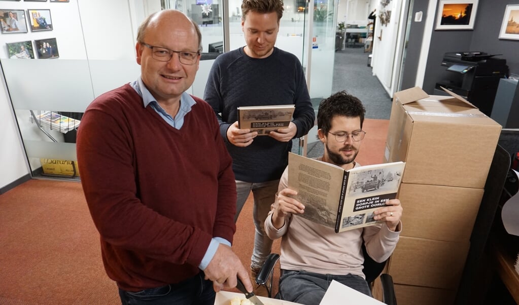 Schrijver Hans snijdt de taart aan. Naast hem ontwerper Ruud van der Pol en hoofdredacteur van DeMooiRooiKrant, Jeroen van de Sande.
