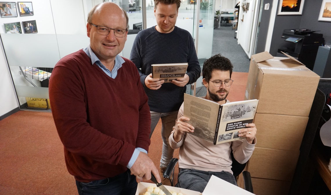 Schrijver Hans snijdt de taart aan. Naast hem ontwerper Ruud van der Pol en hoofdredacteur van DeMooiRooiKrant, Jeroen van de Sande.
