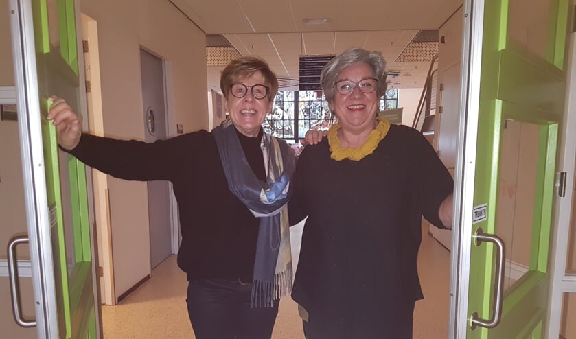 Elly (l) en Lilian voor de herkenbare deuren van hun werkplek. | Fotonummer: d224bb