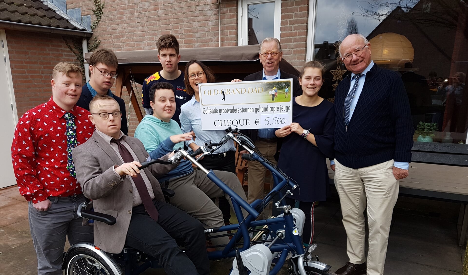 Marieke van Wanrooij met bewoners van wooninitiatief Kamille en sponsoren van Stichting Old Grand-Dad Club bij hun nieuwe fiets.