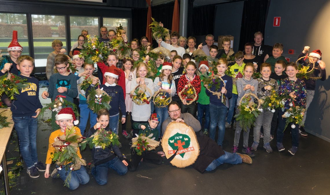 De jeugdnatuurwachters met hun eigengemaakte kerststuk samen met de leiding en wethouder Van der Pas.