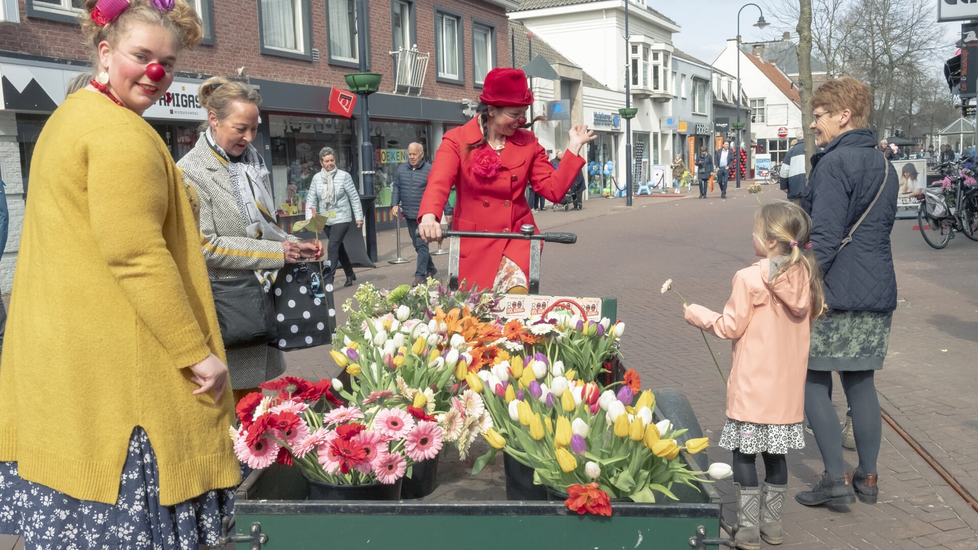Een komisch en kleurrijk duo reed door de straten met een grote bakfiets vol bloemen.