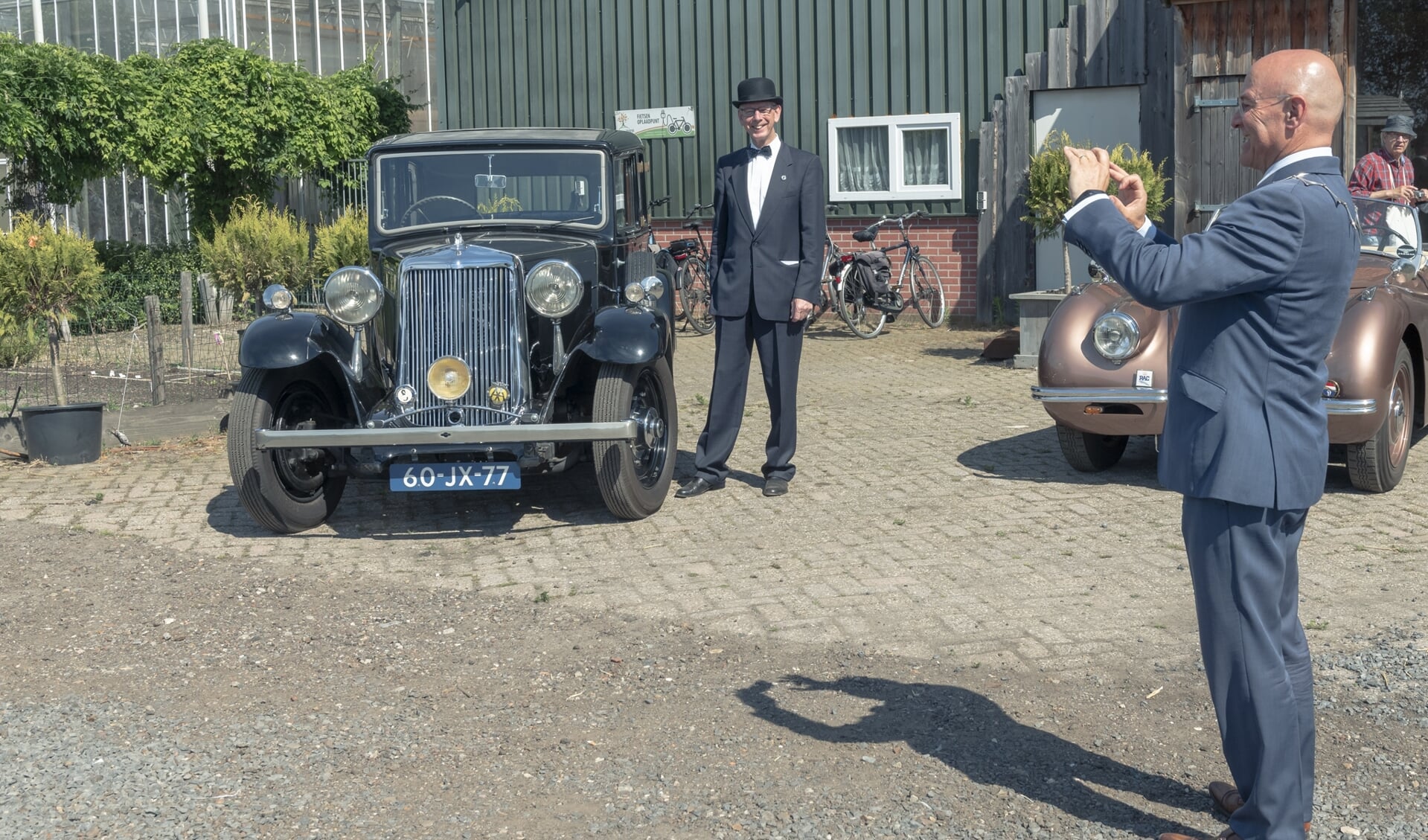 Peter van de Kerkhof poseert bij een auto terwijl de burgemeester foto's maakt.