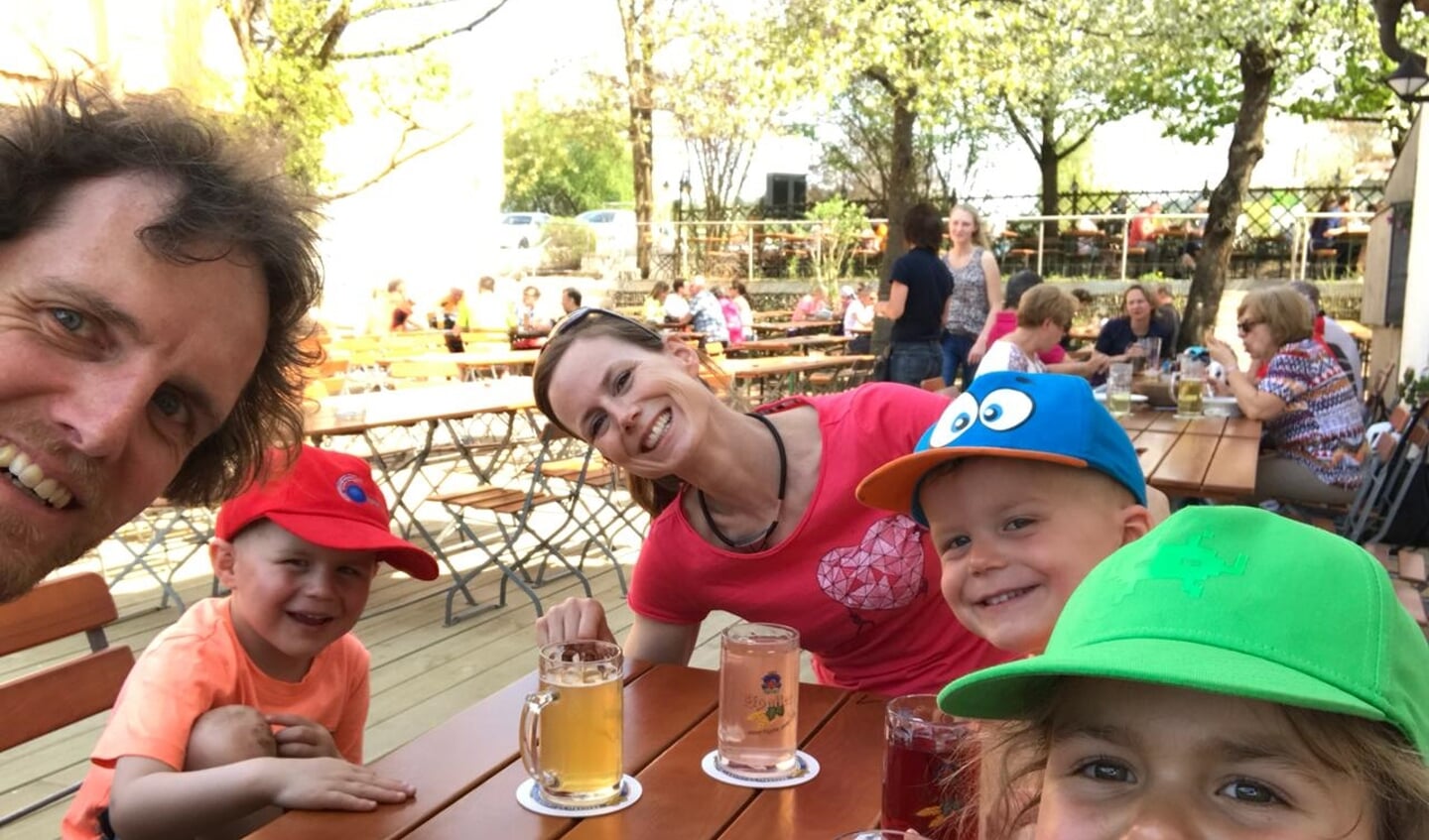 Janneke met haar vriend en de kinderen in een Biergarten.
