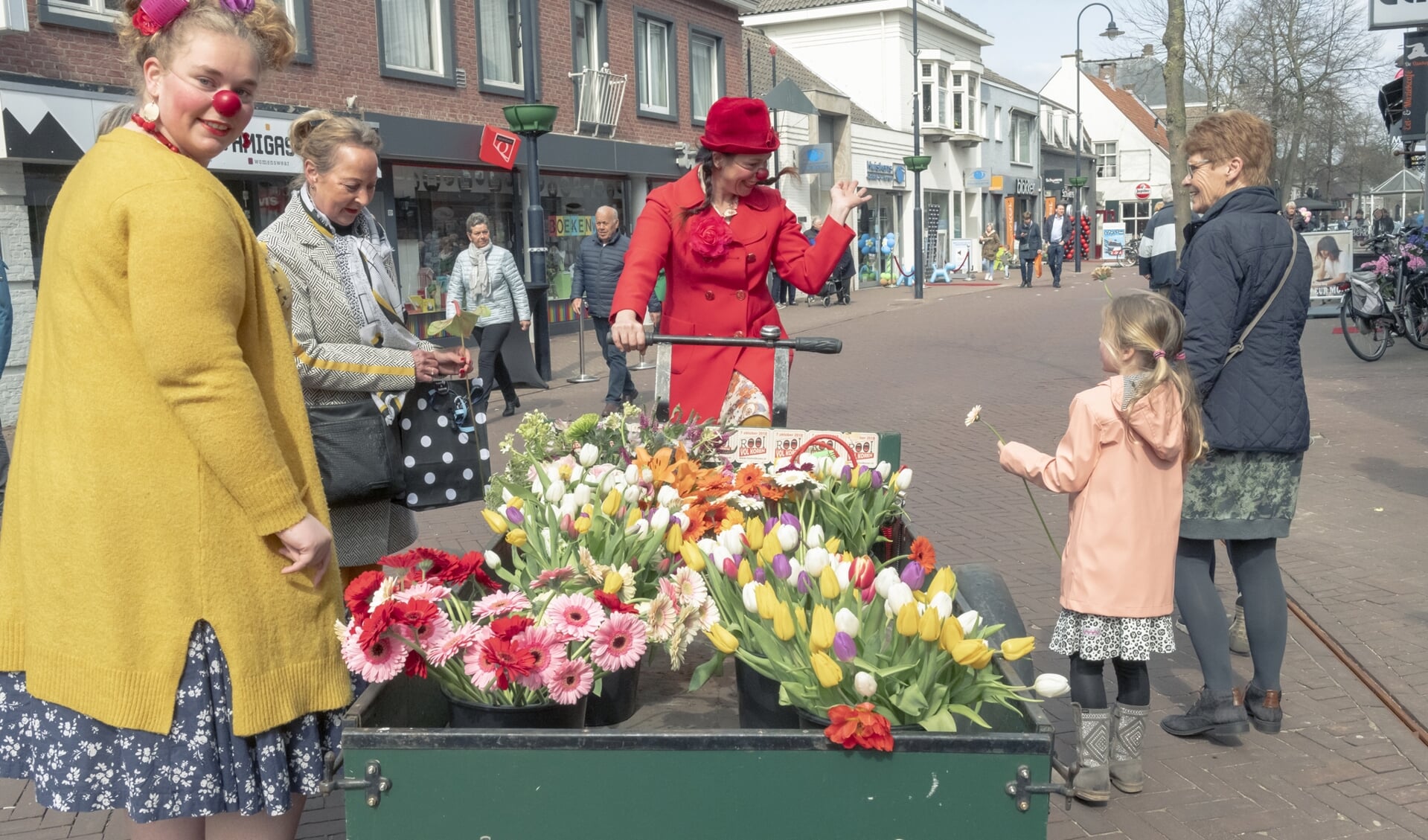 Een komisch en kleurrijk duo reed door de straten met een grote bakfiets vol bloemen.