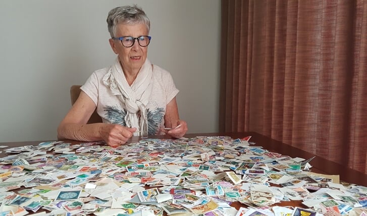 Ria Veldhuis laat duizenden postzegels zien.