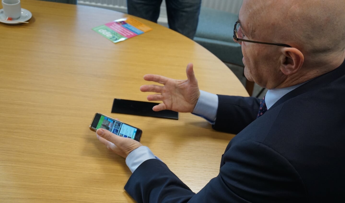Burgemeester Van Rooij opent de app.