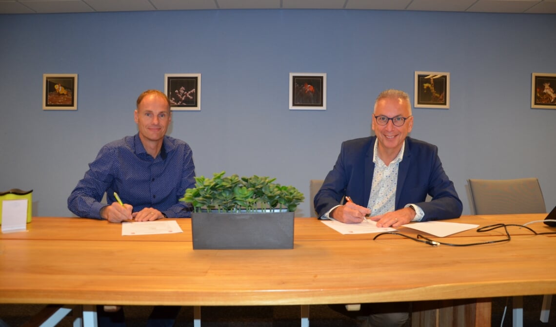 <p>Mark de Wit en Ad van Acht (r) tekenen een nieuw contract.</p>