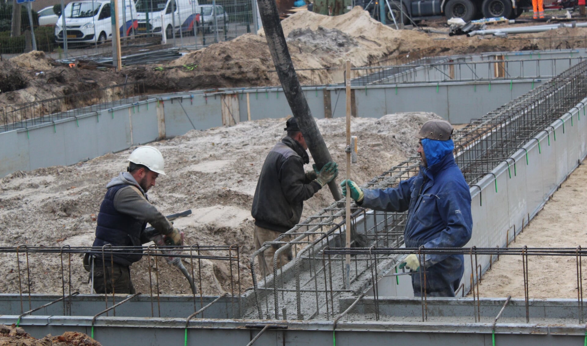 Deze mannen zijn druk bezig met het storten van beton.