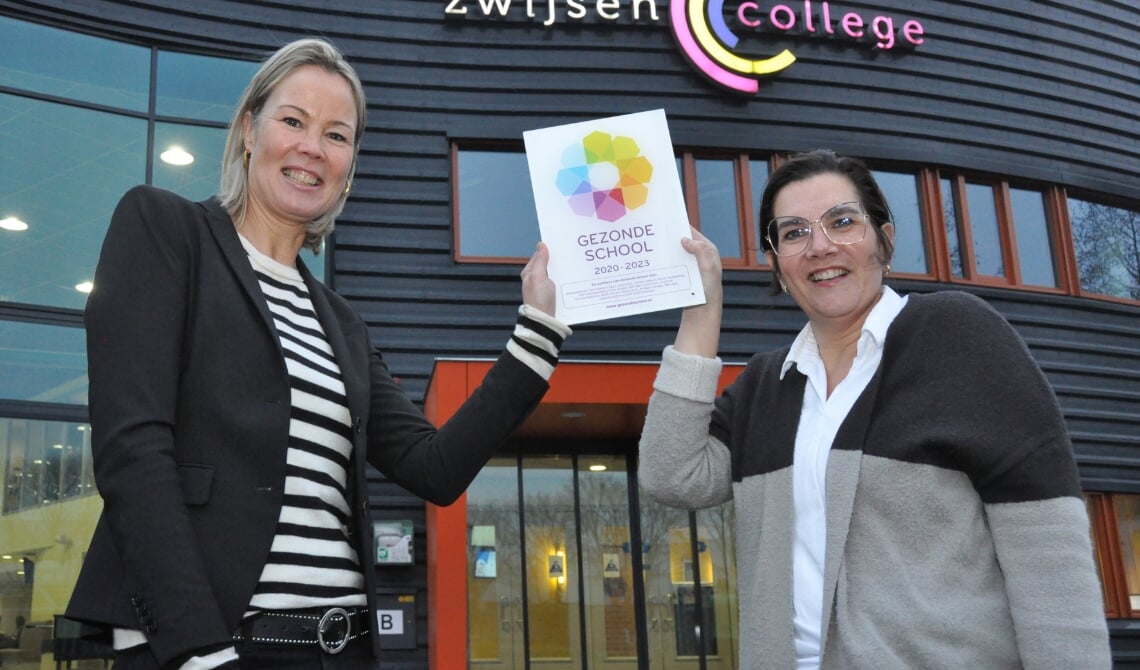 <p>Birgit van Veghel (l), de locatiedirecteur, neemt het vignet in ontvangst.</p>