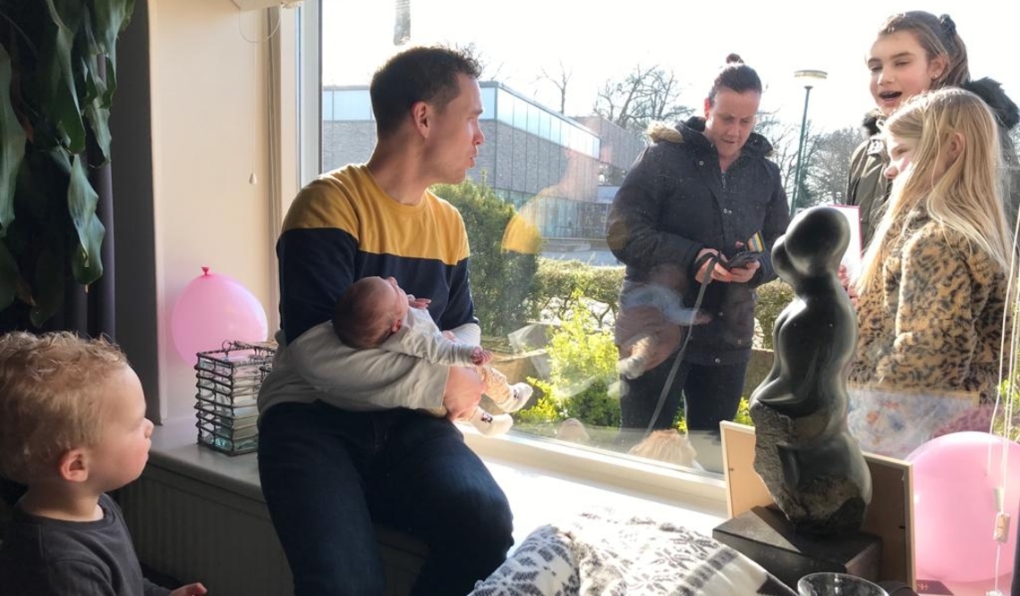 Kaat wordt getoond door het grote raam in de woonkamer.