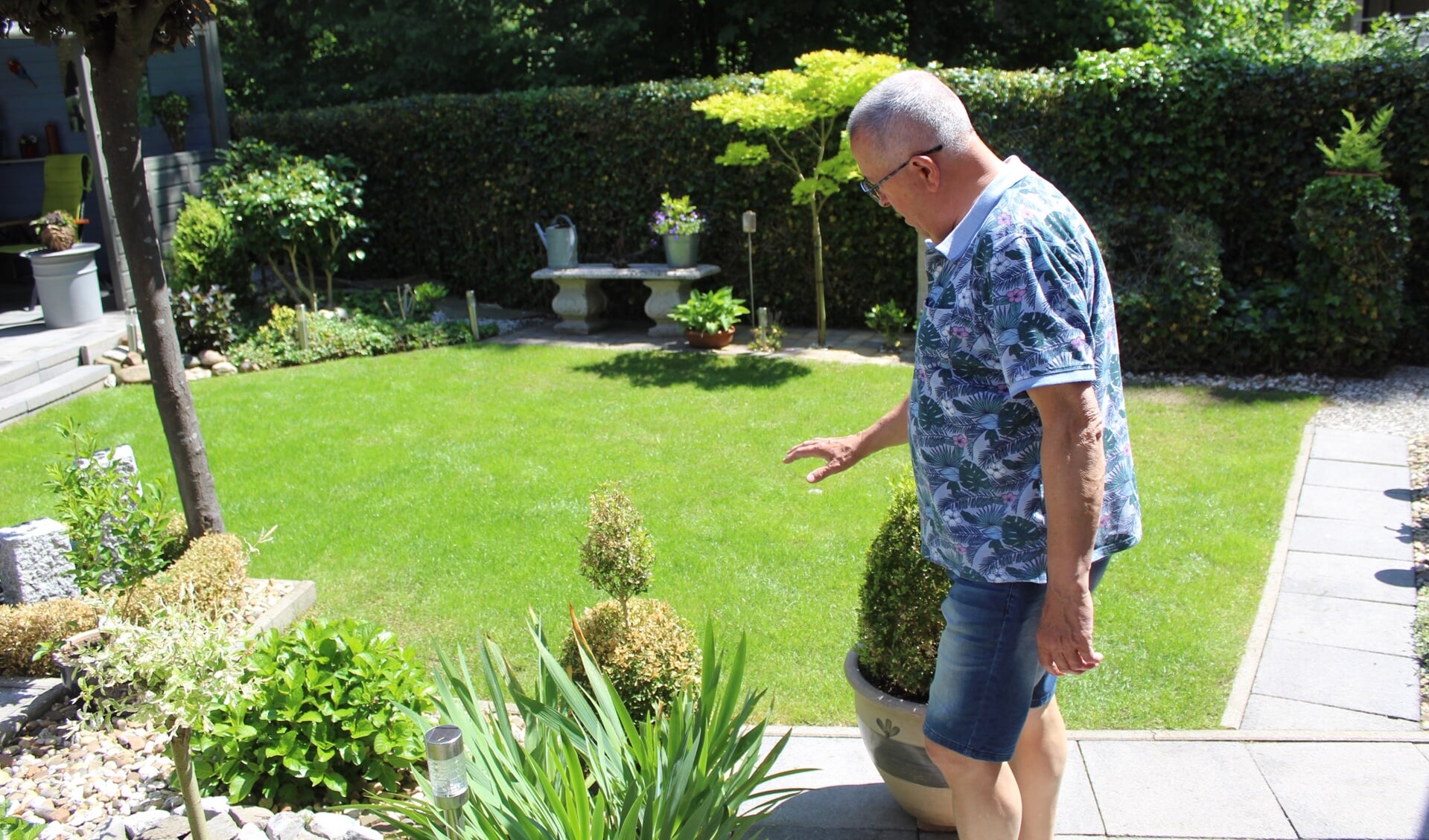 Jan  geeft een rondleiding door de tuin.