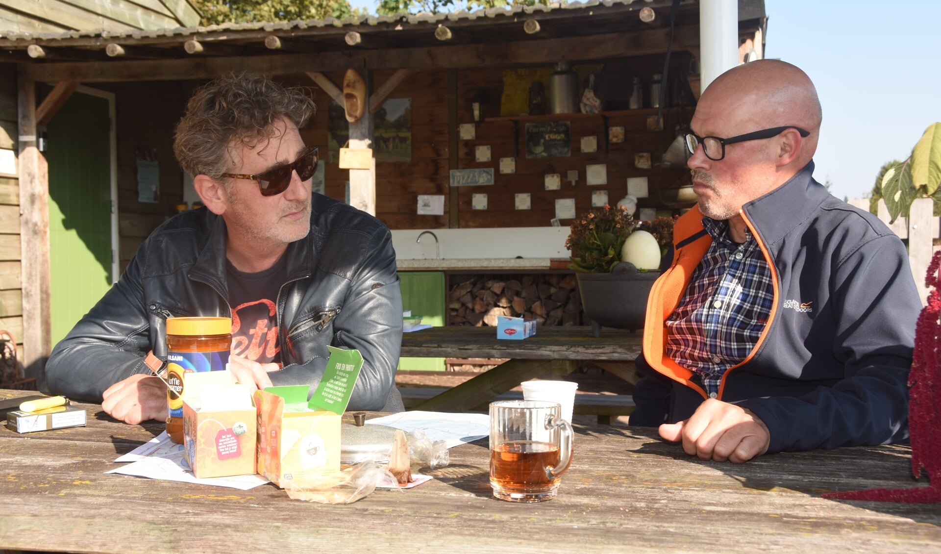 Maurik Wouters (l) van de actiegroep legt een fietser uit wat het betekent als er windmolens worden geplaatst op de Rooise Heide.