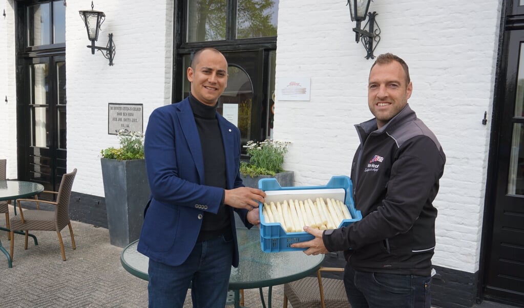 Roy Tweedy neemt dankbaar een kistje asperges van Maarten van Hoof in ontvangst.