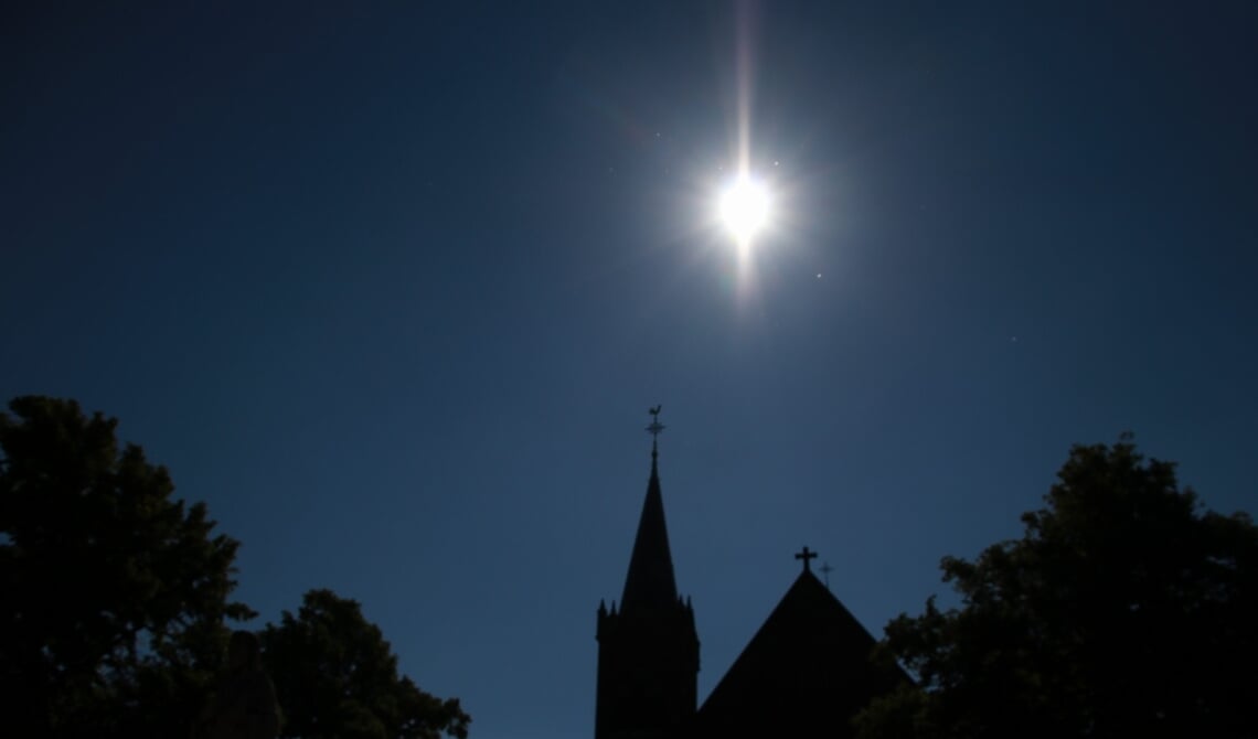 <p>Stralende zon boven de kerk</p>