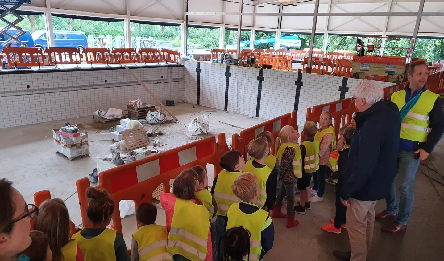 De kinderen luisteren aandachtig naar de gids.