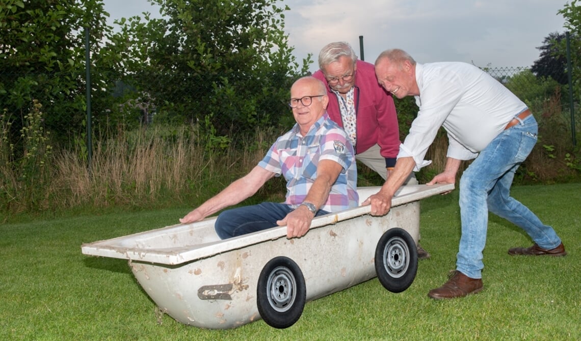 <p>Toon Schuurmans (rode vest) en Wil Markus duwen Ad Huijbers voort in de eerste zeepkist.</p>