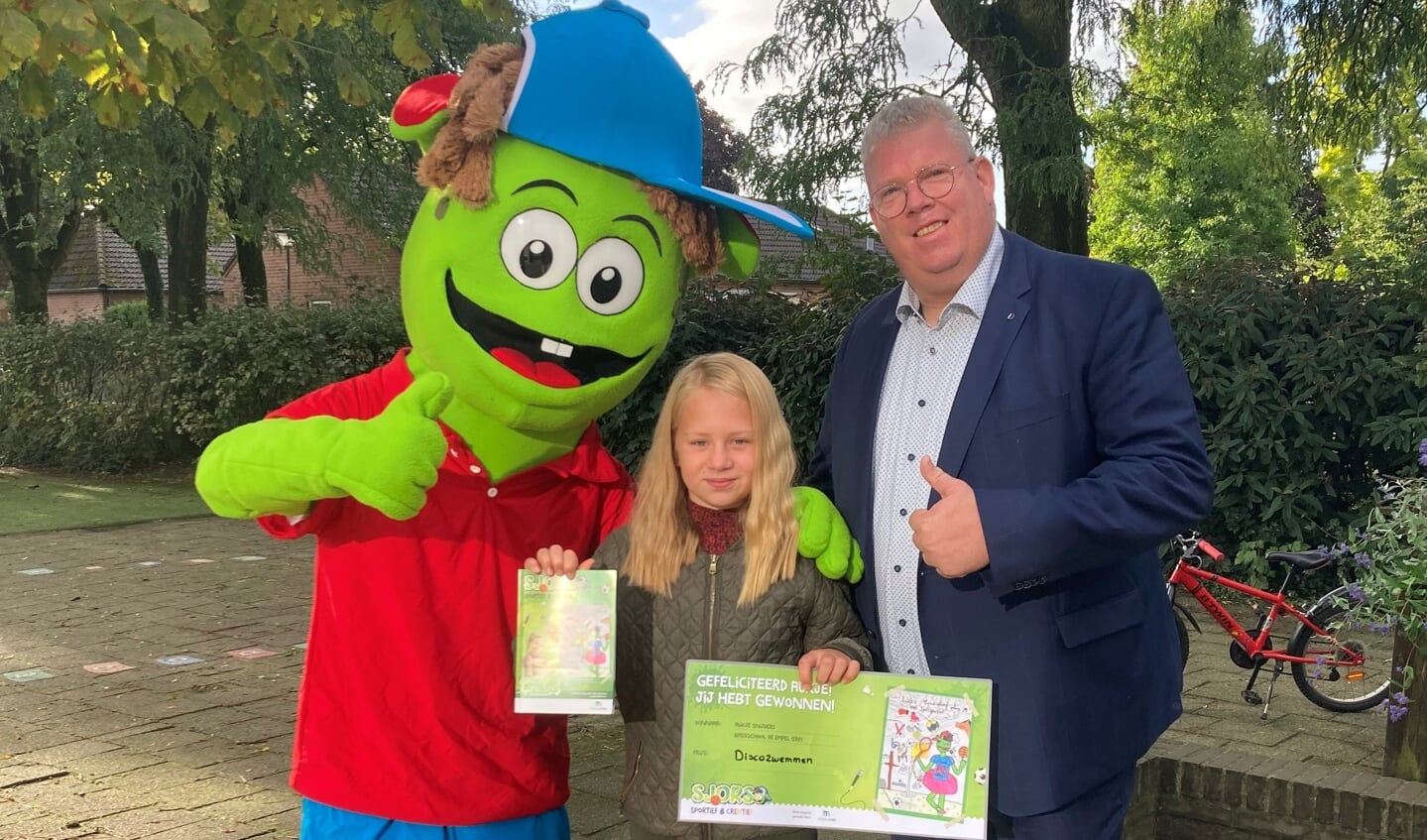 Aukje Snijders krijgt het eerste boekje uit handen van Sjors Sportief en wethouder Johan van Gerwen