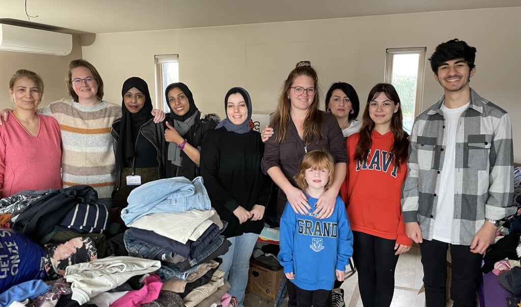 Leanne, rechts in het midden met haar dochtertje, met een collega en enkele vluchtelingen.