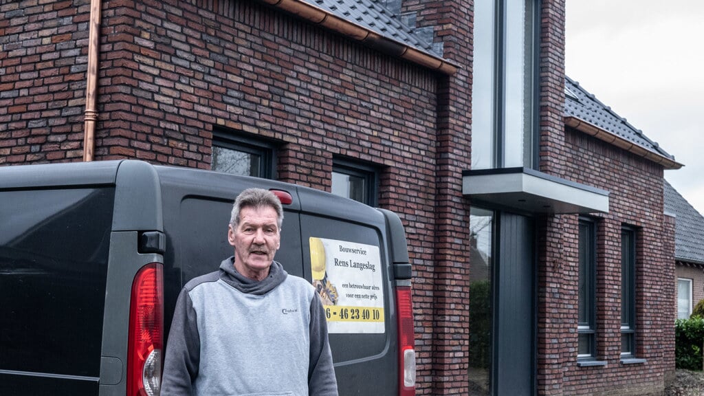 Rens Langeslag voor het door hem gebouwde huis.