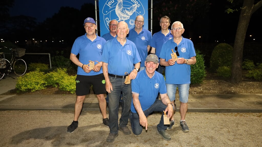 Kampioen Kees Luijten (midden staand) ontvangt de 1e prijs uit handen van de wedstrijdwerkgroep.