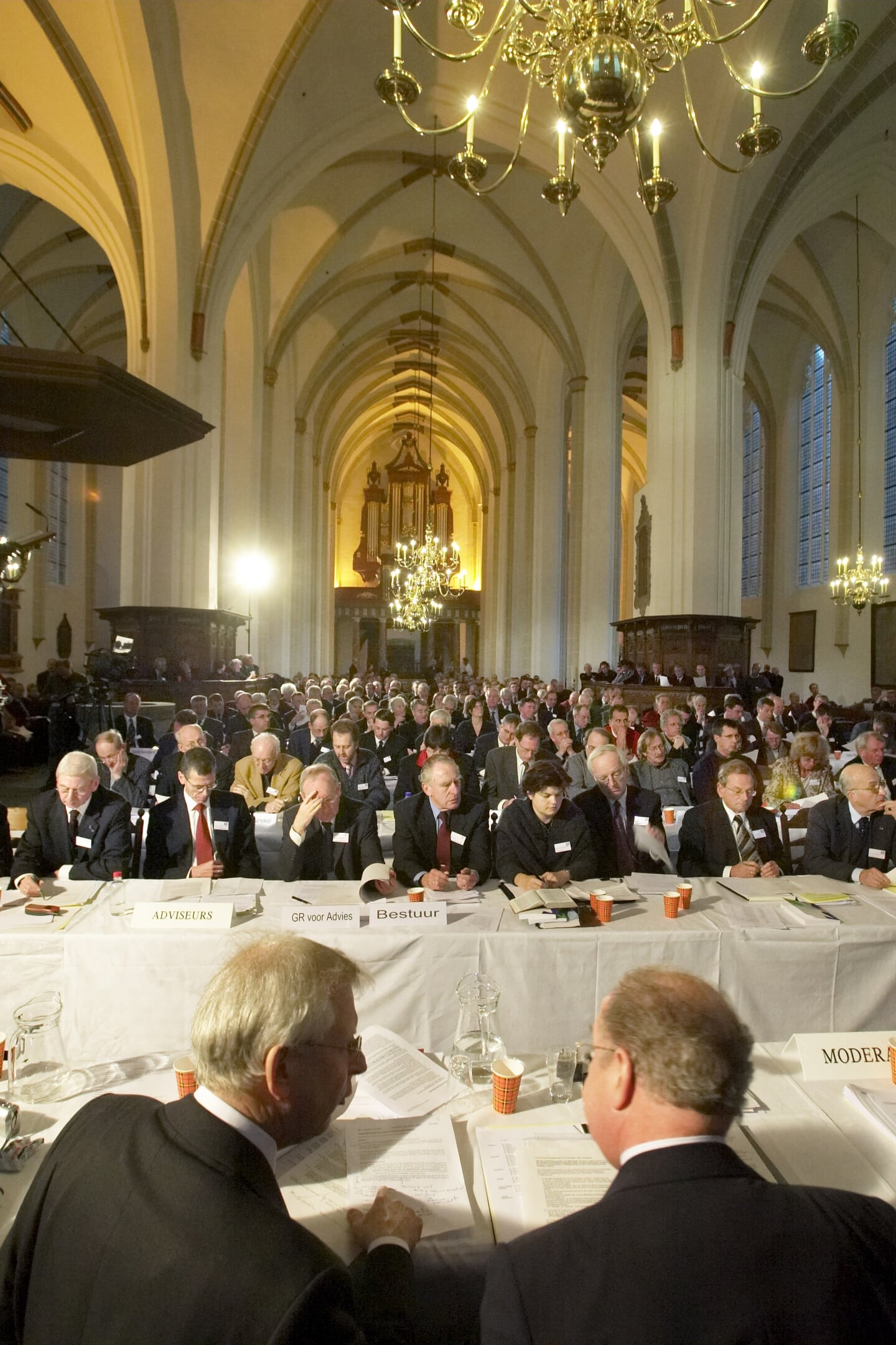 Bas Plaisier (links op de rug gezien) tijdens de beslissende synodevergadering over de kerkenfusie, december 2003 in de Utrechtse Jacobikerk.
