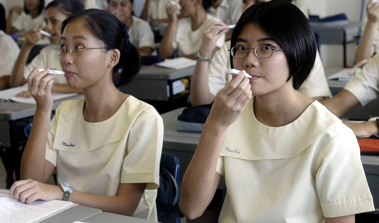 Studenten van een school in Singapore checken hun temperatuur in de nadagen van het SARS-virus in 2004. 
