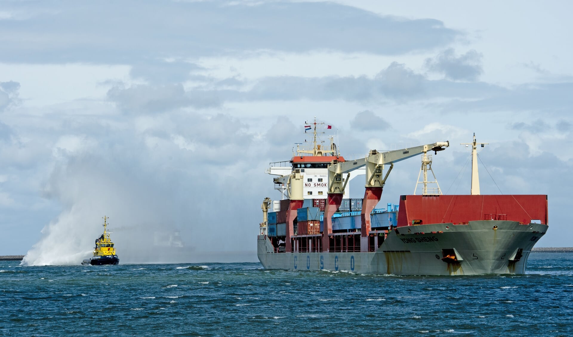 Een Chinees vrachtschip komt aan in de Rotterdamse haven. Veel te goedkope spullen worden de hele wereld over getransporteerd. 