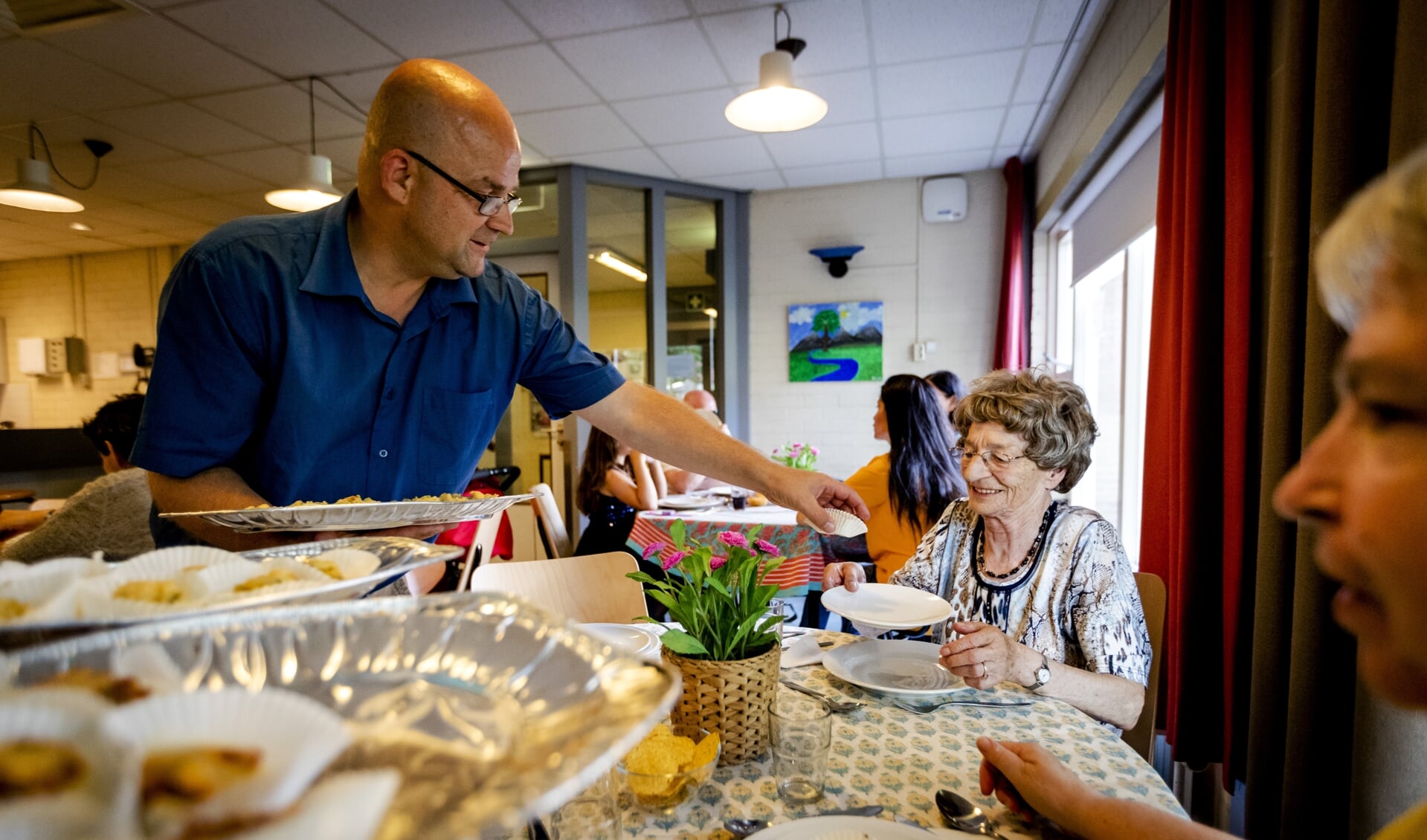 Een vrijwilliger deelt maaltijden uit aan minderbedeelden in Utrecht.