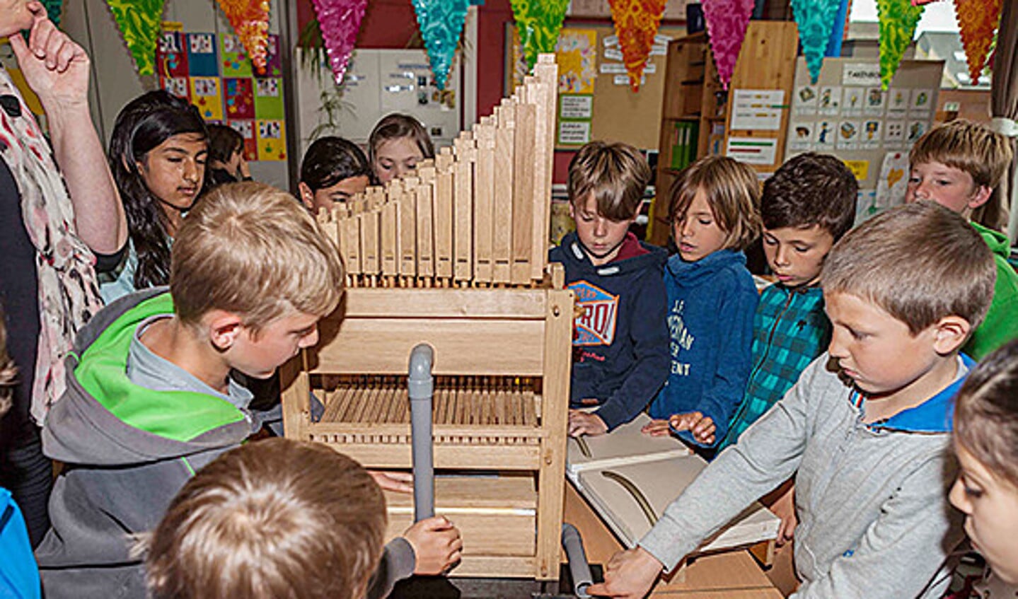 Kinderen zetten het bouwpakket van een Doe-Orgel in elkaar.