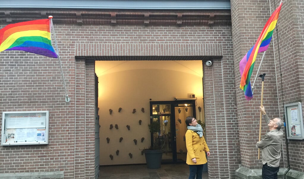 Kerkleden hijsen de regenboogvlag als teken van acceptatie van lhbt’ers, in Amsterdam. (beeld protestantse kerk amsterdam)