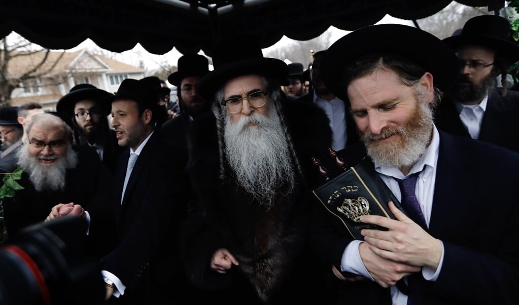 Rabbijn Chaim Rottenberg (midden, met grote baard) tijdens een ceremonie in Monsey, zondag. (beeld EPA/PETER FOLEY)