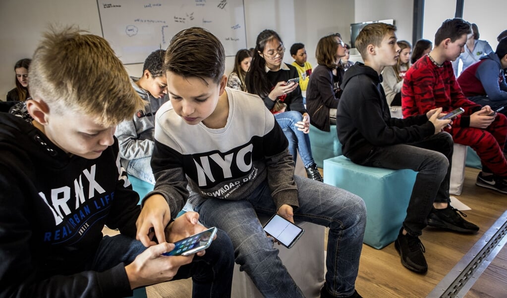 Scholieren van het Van Maerlantcollege in Den Bosch aan het werk in het mobiele klaslokaal van de Smartbus. ( beeld Arie Kievit)